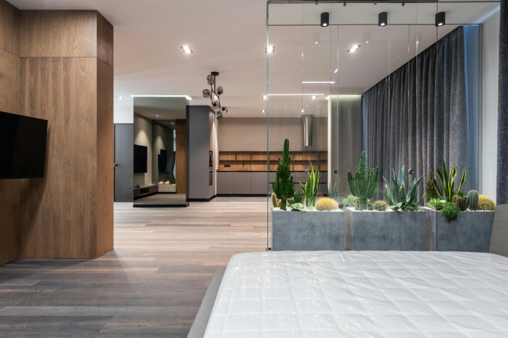 Ventes Spacious modern interior featuring a glass wall and vibrant indoor plants.